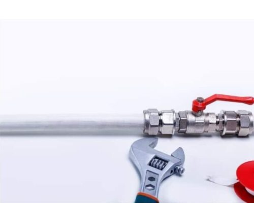 A pipe with a red valve, an adjustable wrench, and plumber’s tape used for plumbing repairs in LA County.